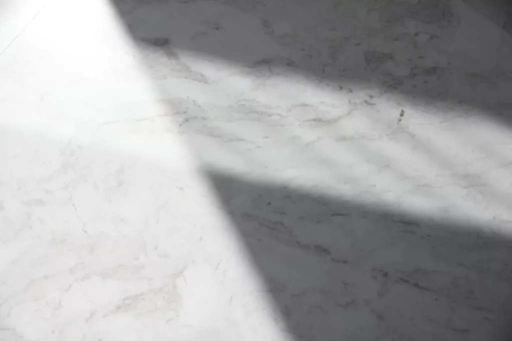 a white marble counter top with a long shadow